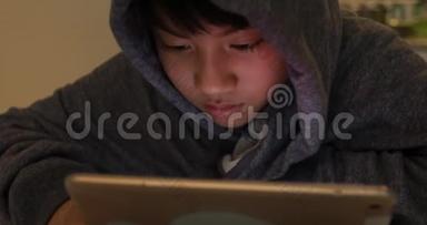 可爱的亚洲男孩使用<strong>平板</strong>电脑，年轻的十几岁男孩在数字<strong>平板</strong>电脑上玩游戏，带着<strong>微笑</strong>的脸。